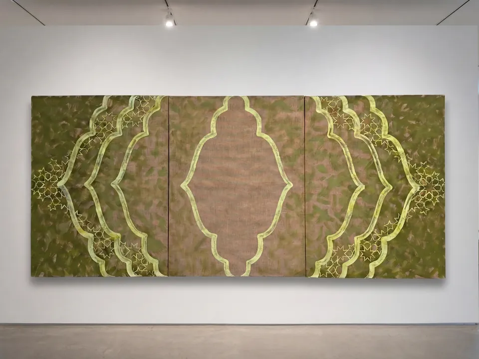 Vue d’installation : grand triptyque sur toile de jute, motifs de portes marocaines en vert et jaune pâle, fragmentés et déplacés sur un fond kaki.